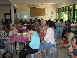 Devotees praying as Rev and priest chant the prayers in Burmese Temple, Penangx