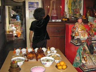 Aunty Yean inviting her honorable ancestor that food is serve Aunty Yean inviting her honorable ancestor that food is serve