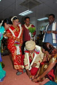 Putting toe rings on his bride in traditional Wedding Putting toe rings on his bride in traditional Wedding