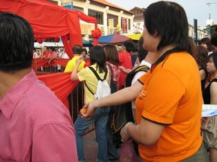 Lady throwing orange during chap goh meh in penang Lady throwing orange during chap goh meh in penang
