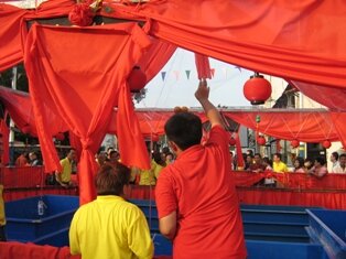 Man throwing oranges during chap goh meh in penang