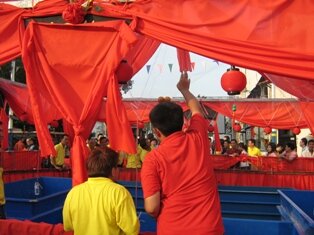 Man throwing oranges during chap goh meh in penang Man throwing oranges during chap goh meh in penang